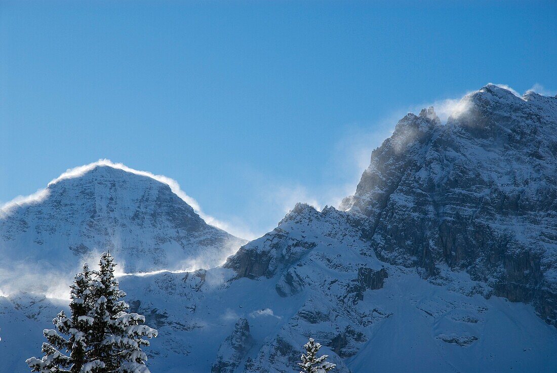 Wind blows fresh snow over mountain ridges, Bernese alps, Gimmelwald, Switzerland