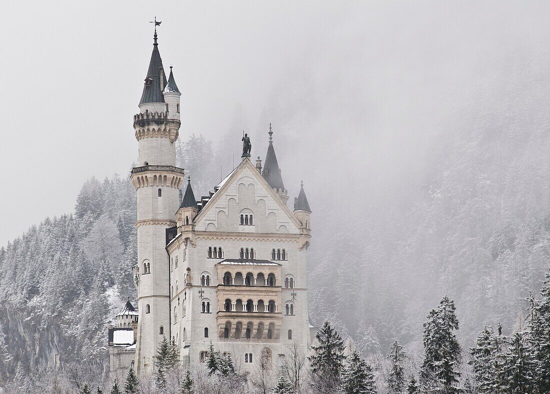Snow covered mountains surround the famous Neuschwanstein castle, Schwangau, Bavaria, Germany