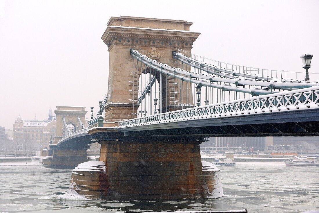 South side of the Szechenyi lánchíd Chain Bridge in the winter snow looking towards the castle district Budapest Hungary.