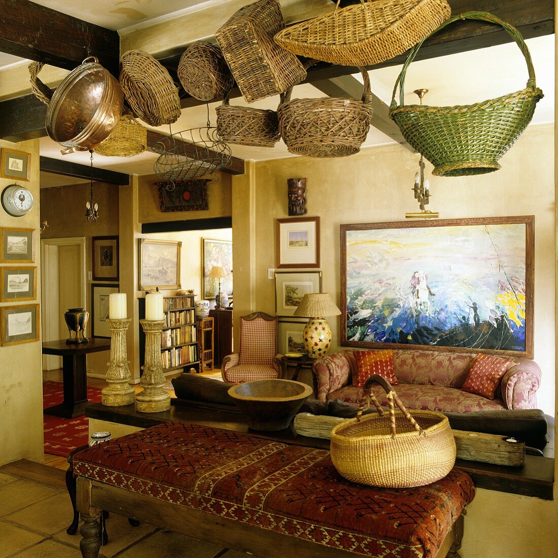 Cozy living room in an old country home with baskets hanging from the timbered ceiling