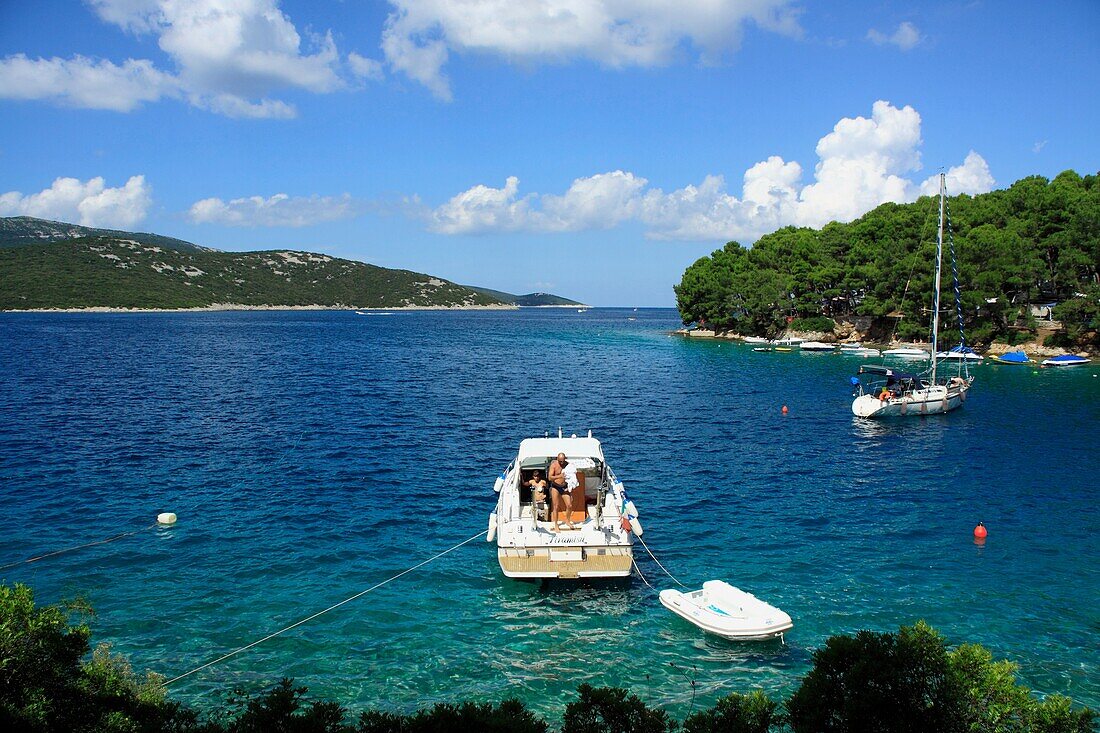 A boat and a yacht with tourists in a small bay in Osor village on Cres Island, Croatia