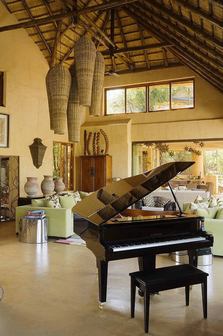 A piano and a bench in an open-plan living room in a South African country house