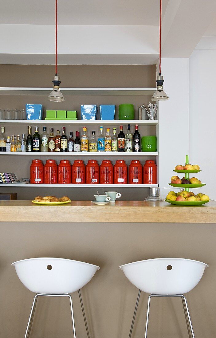Breakfast at a bar - white stools in front of a bar and a shelf in the wall niche