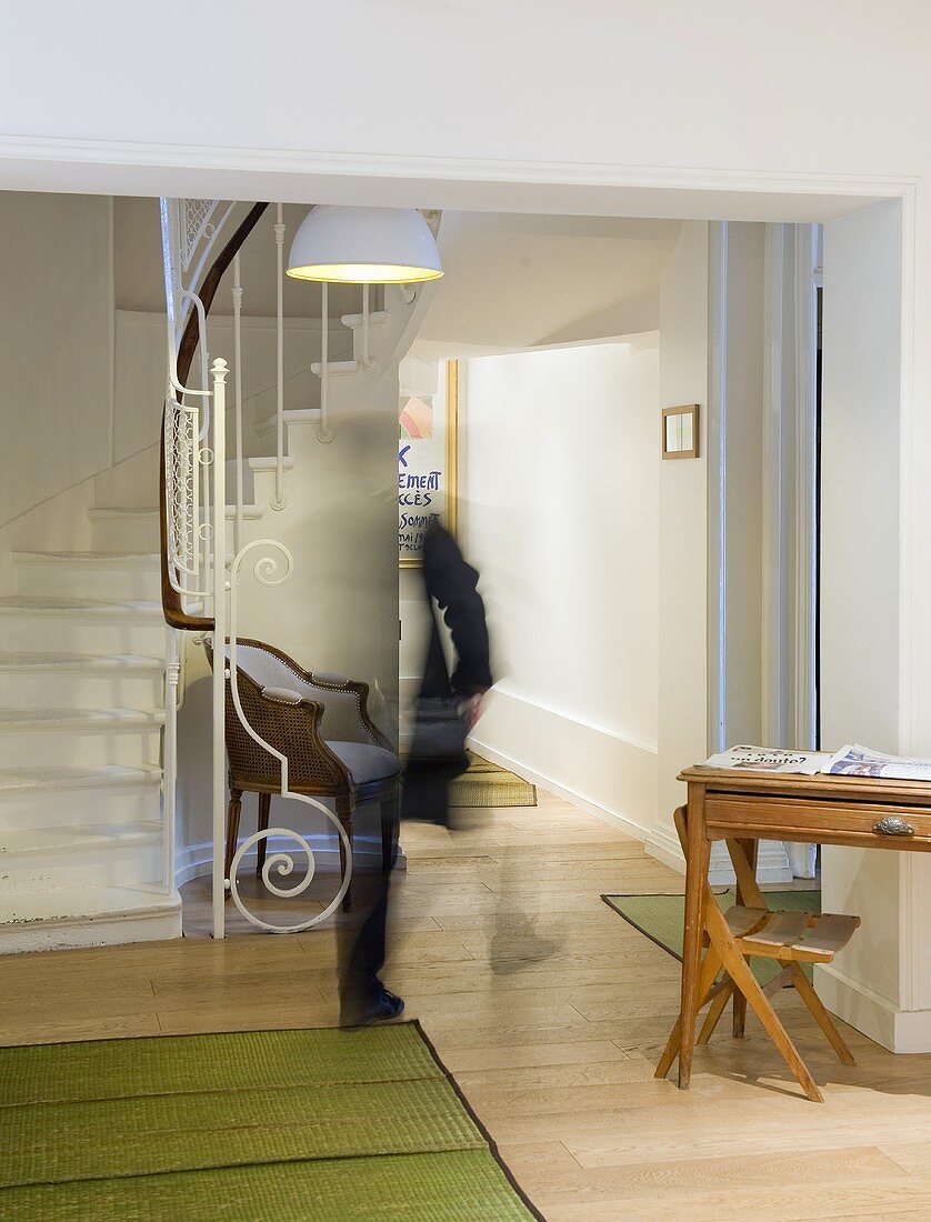 Miniempfang im Altbautreppenhaus mit Kunstschmiede-Geländer an Treppe und grüne Bambusmatten auf Holzboden