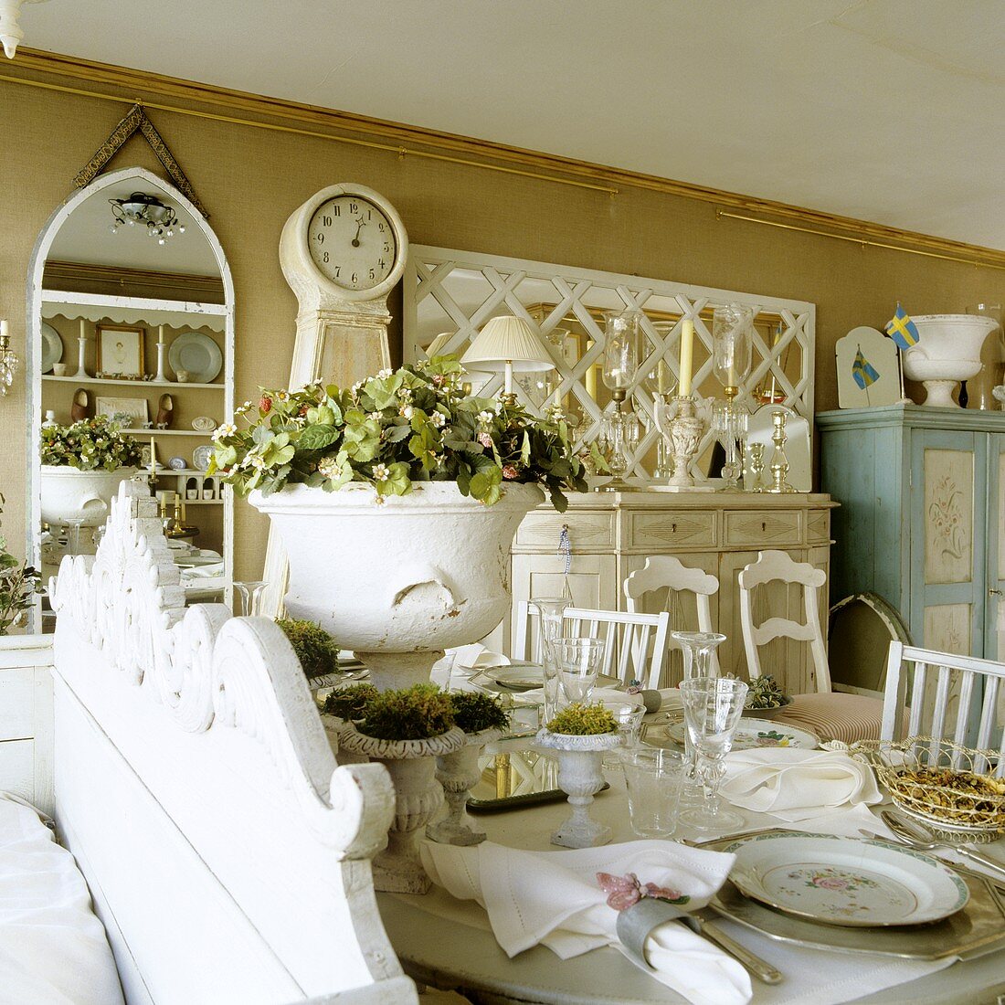 A table laid with a white, antique pot of flowers