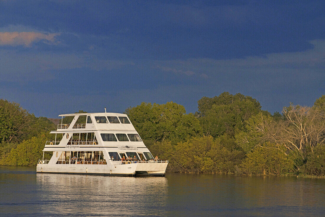 Cruise along the Victoria Falls aboard the  African Queen. Other boats sailing in the Zambezi River. This is the Lady Livingstone? boat. The newly built lady Livingstone famously known as The Jewel of the Zambezi has a capacity of 144 pax. Guests are met