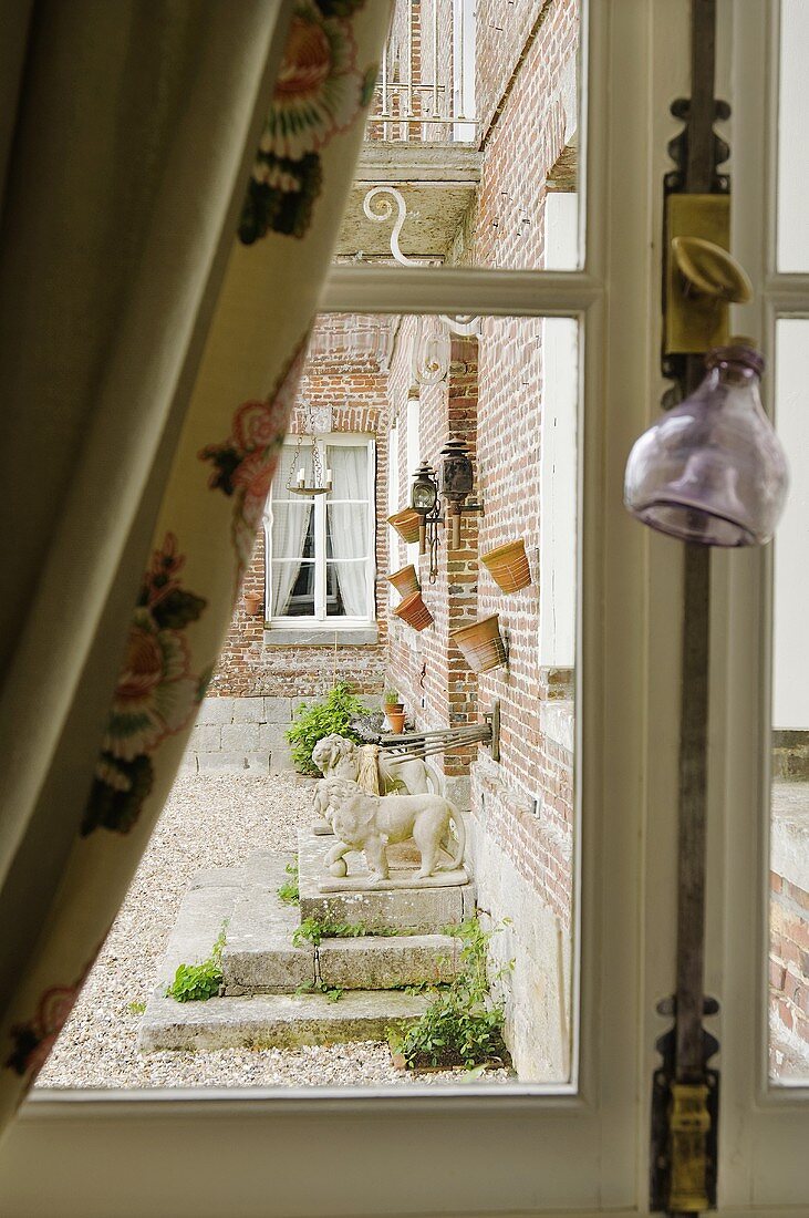 A view through a window of a brick facade of a country house
