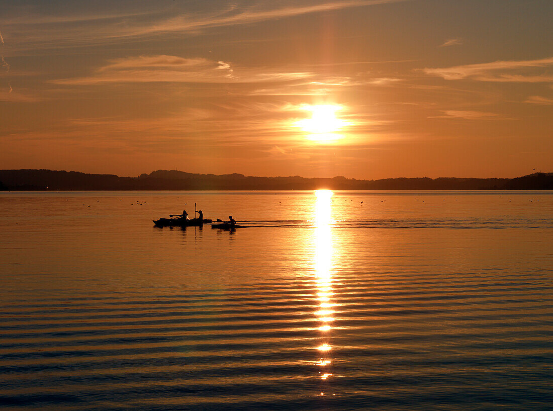 Kayakers at sunset, Bay of Feldwies, lake Chiemsee, Bavaria, Germany