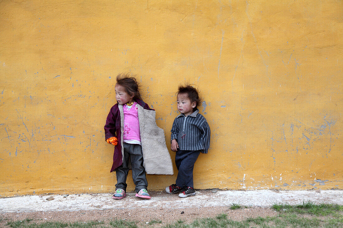 Kinder vor gelber Hauswand, nahe Ulaanbaatar, Mongolei