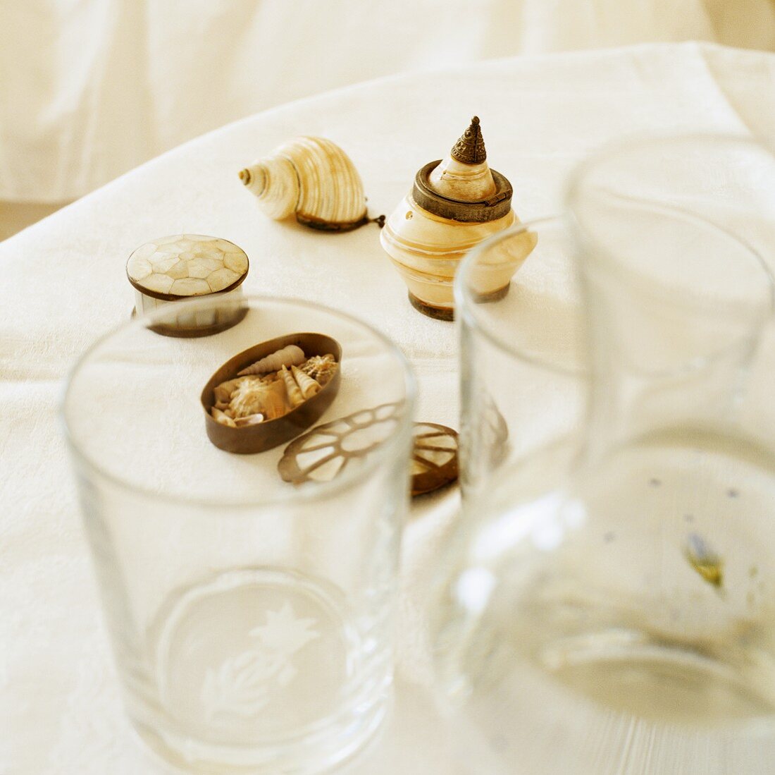 Mother of pearl boxes and seashells on a white shelf