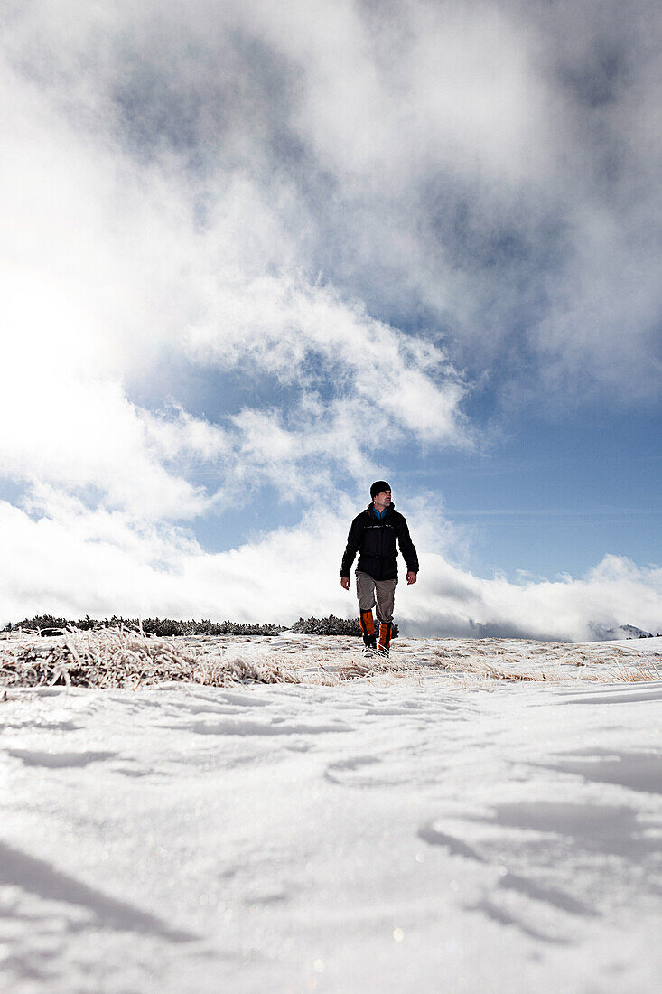 Wanderer läuft in verschneiter Landschaft, Aufstieg zum Unnütz (2078 m), Rofan, Tirol, Österreich