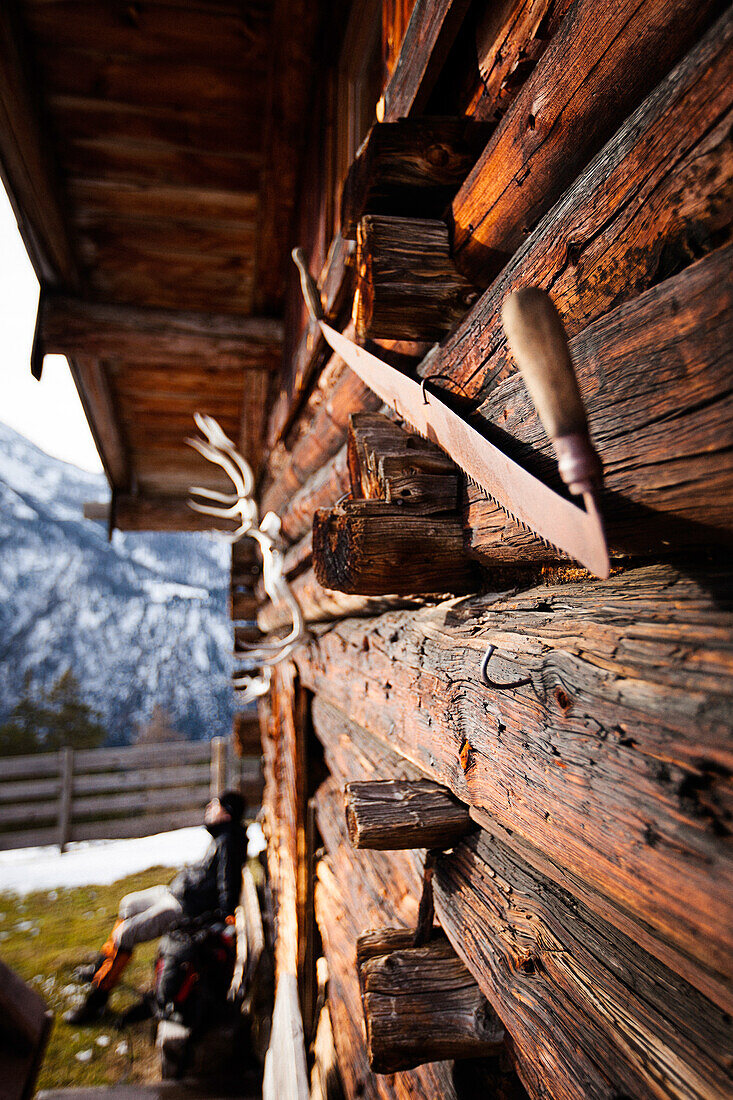 Wooden hut and hiker taking a rest, descent from Unnutz Mountain (2078 m), Rofan Mountains, Tyrol, Austria