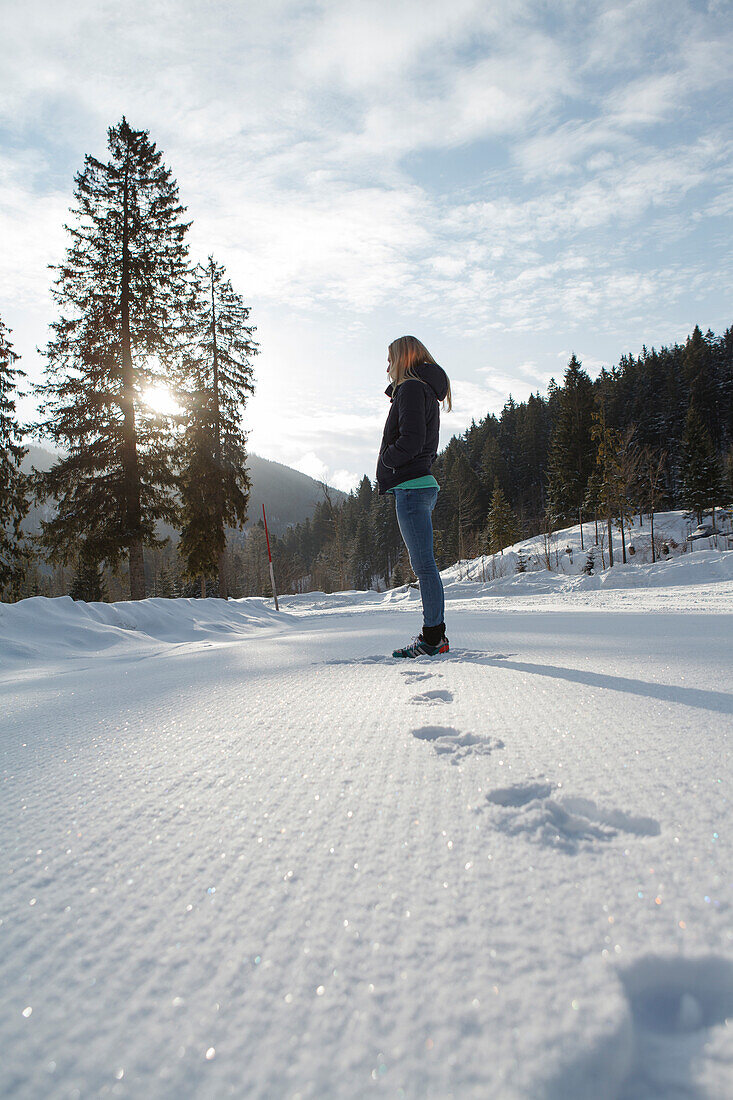 Junge Frau steht im Schnee, Spitzingsee, Oberbayern, Bayern, Deutschland