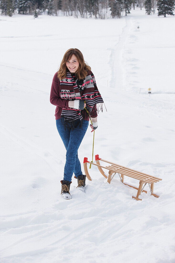 Young woman with a sled, Spitzingsee, Upper Bavaria, Germany