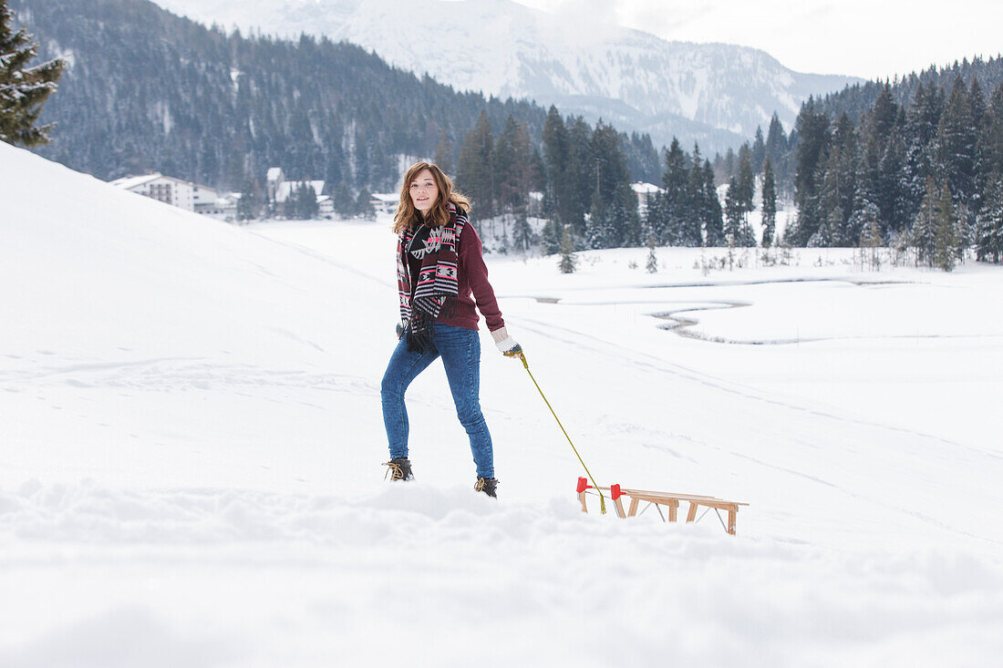 Junge Frau mit einem Schlitten, Spitzingsee, Oberbayern, Bayern, Deutschland