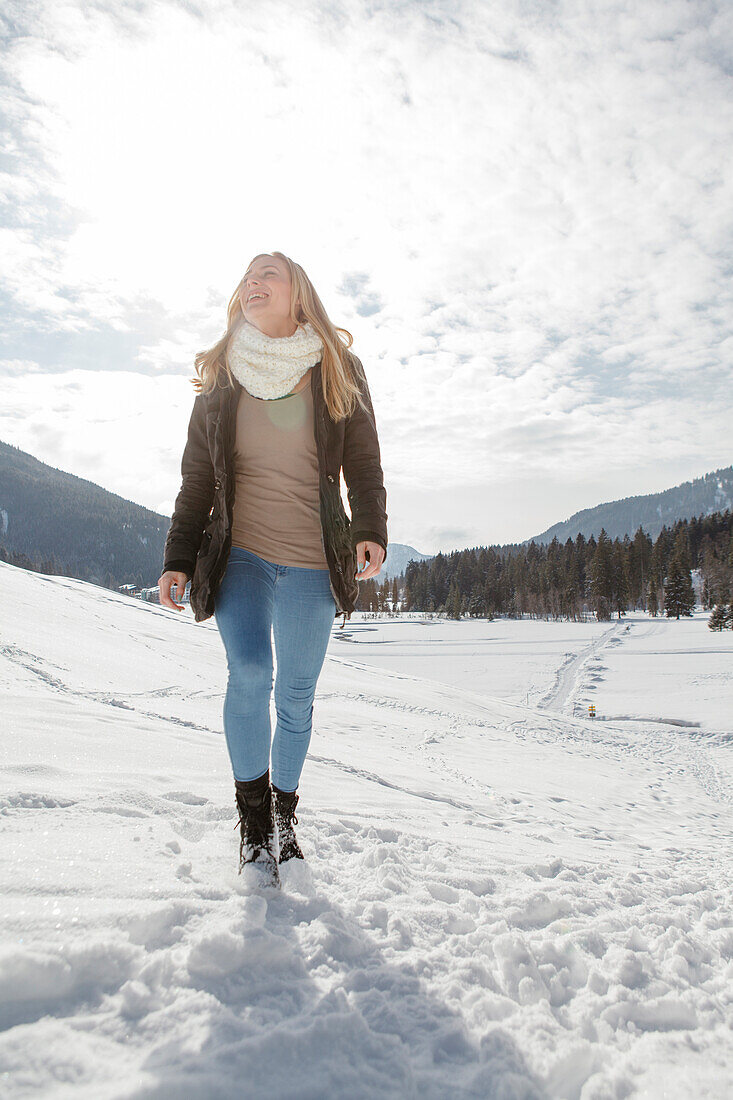 Junge Frau geht im Schnee spazieren, Spitzingsee, Oberbayern, Bayern, Deutschland