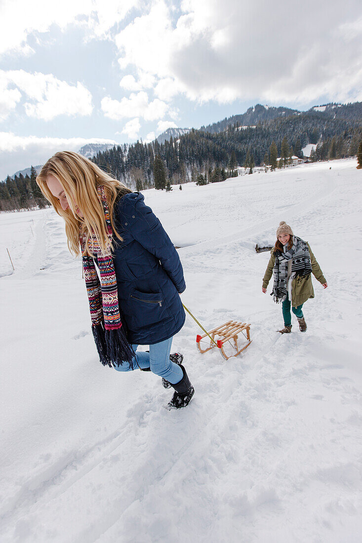 Two young women with a sled, Spitzingsee, Upper Bavaria, Germany