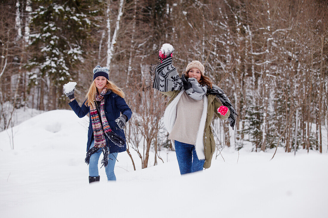 Zwei junge Frauen bei einer Schneeballschlacht, Spitzingsee, Oberbayern, Bayern, Deutschland