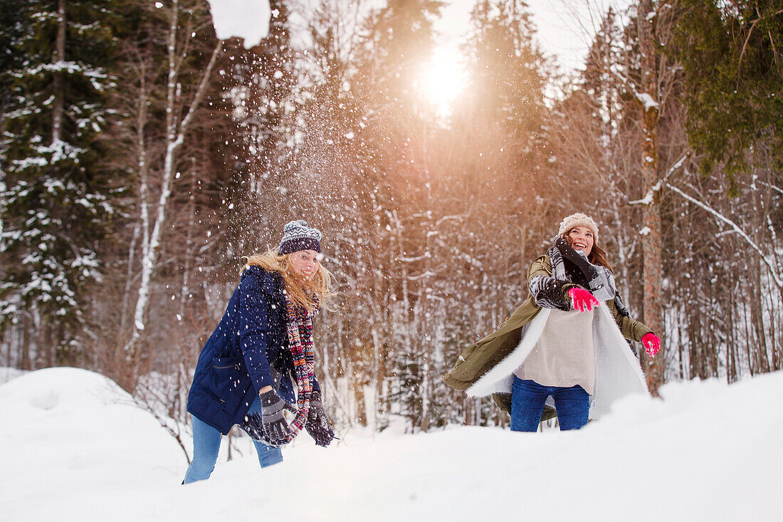 Two young women throwing snowballs, Spitzingsee, Upper Bavaria, Germany