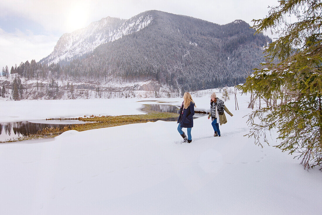 Two young women in snow, Spitzingsee, Upper Bavaria, Germany