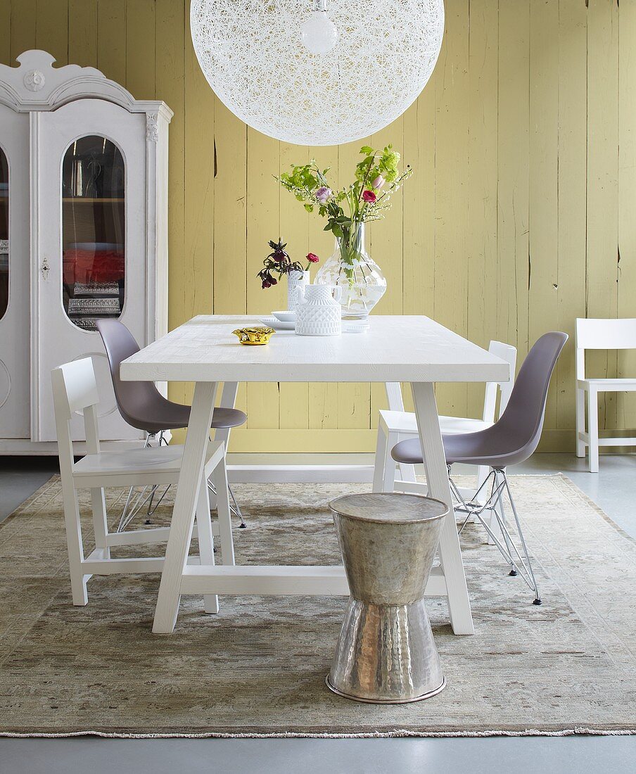 A mixture of styles in a dining room - table and chairs in a country house and Bauhaus style