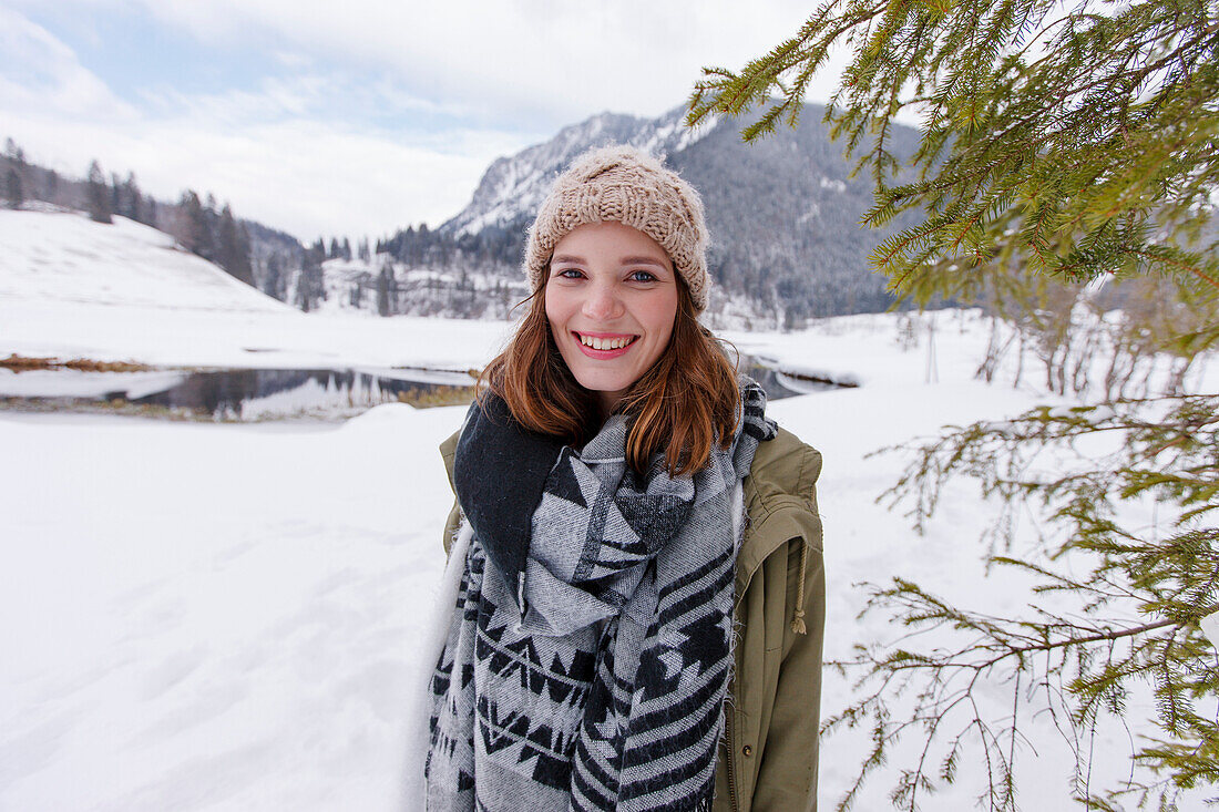 Frau im Schnee lächelt in die Kamera, Spitzingsee, Oberbayern, Bayern, Deutschland