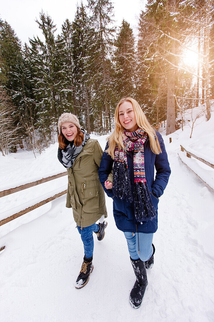 Zwei junge Frauen spazieren Arm in Arm, Spitzingsee, Oberbayern, Bayern, Deutschland