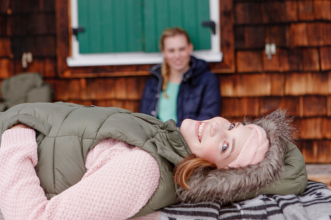 Two young women outside of a cabin, Spitzingsee, Upper Bavaria, Germany