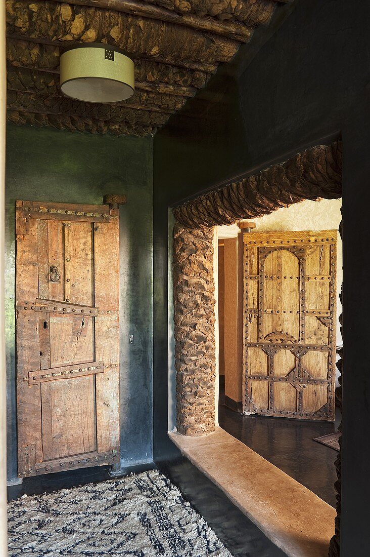 Vorraum mit rustikaler Zimmertür und Blick in offenem Nebenraum eines Mediterraner Landhauses