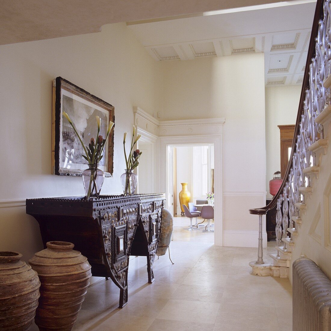 An antique Oriental wall table in the hallway of a villa with a view into the living room