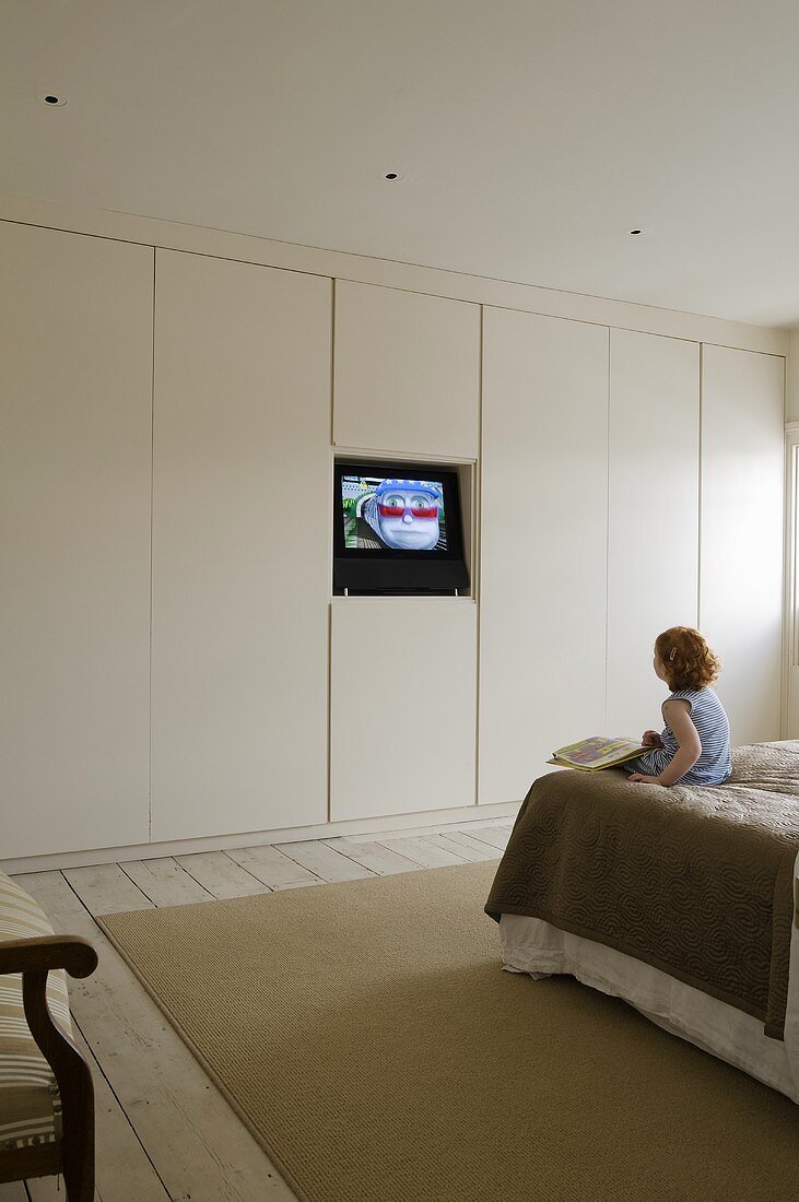 A child watching television in a bedroom