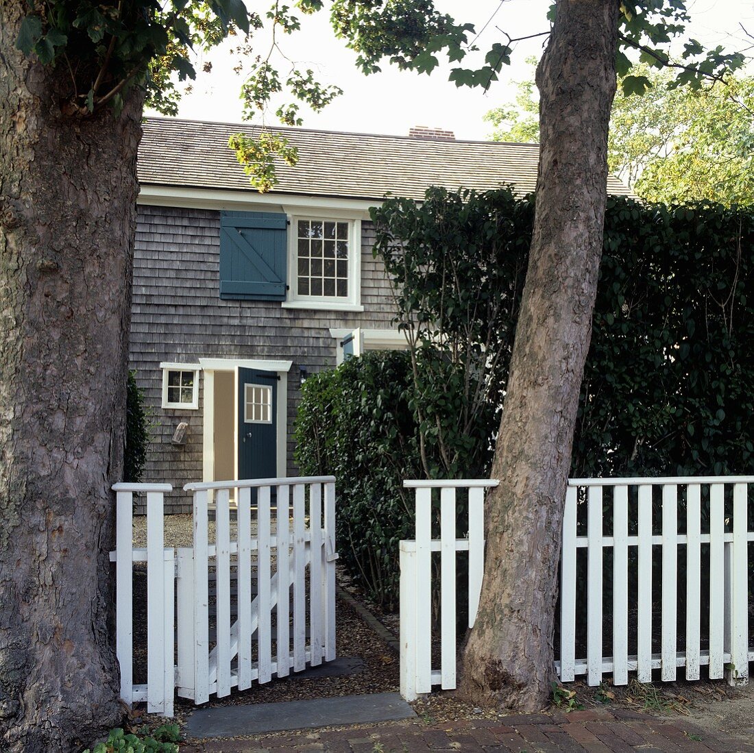A detached house with a white garden fence