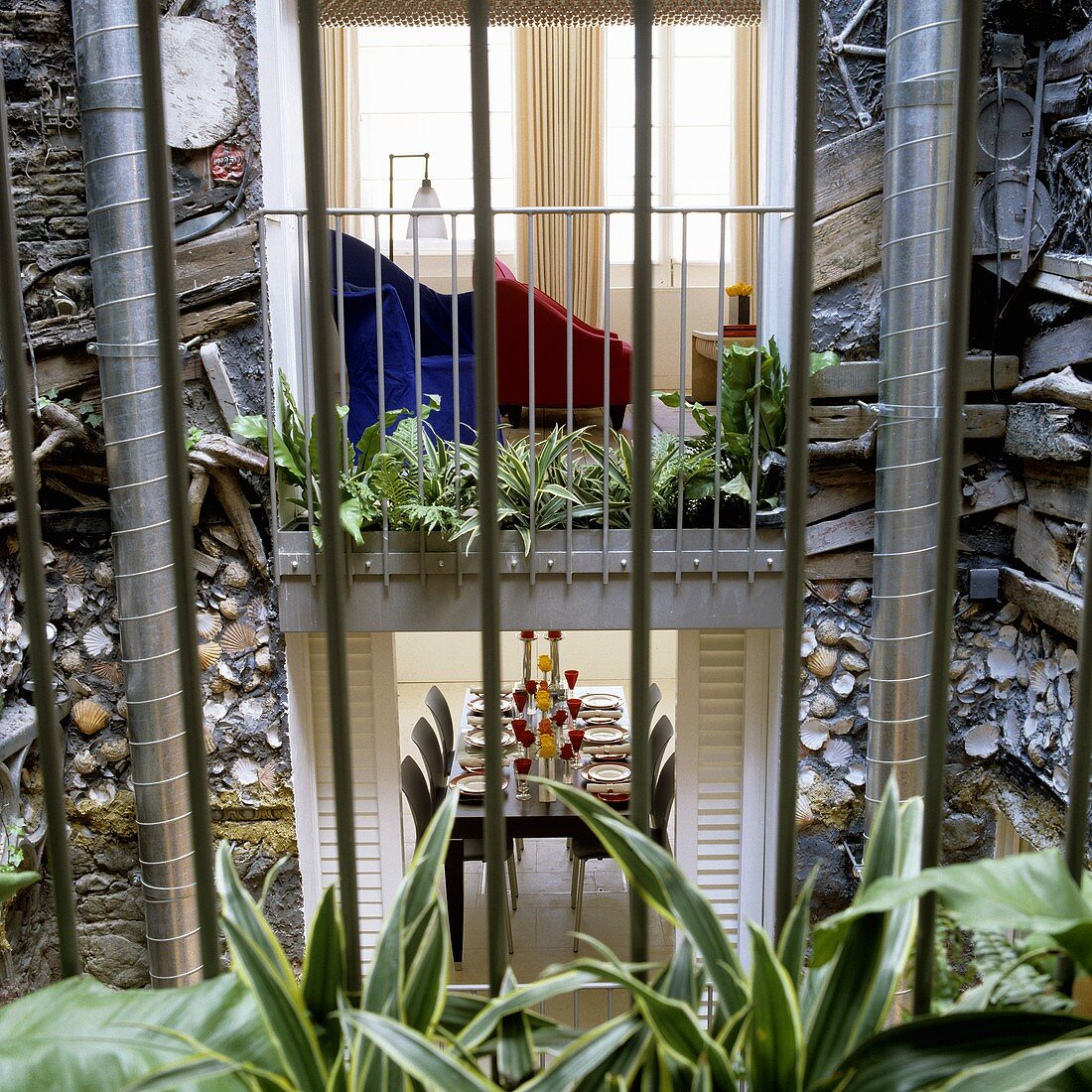 Blick vom Innenhof auf raumhohe Fenster mit Einsicht und künstlerisch gestalteter Fassade