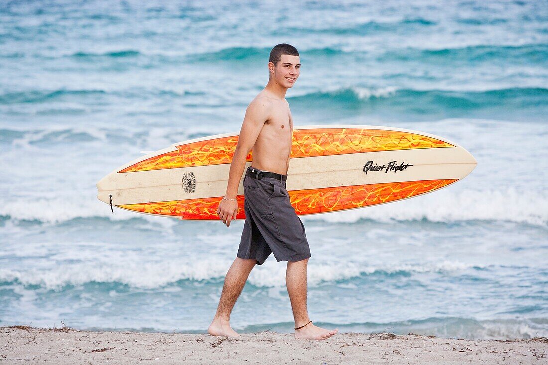 Teen surfer with his surfboard