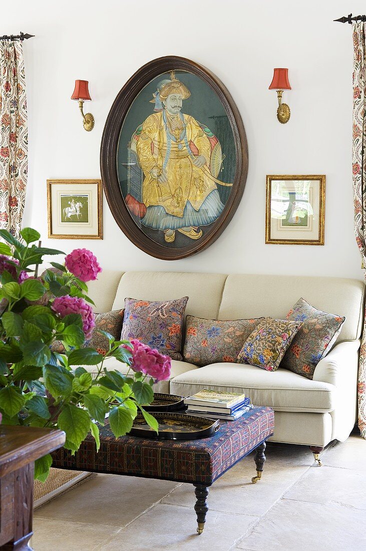 An upholstered, oriental-style coffee table and a sofa against the wall