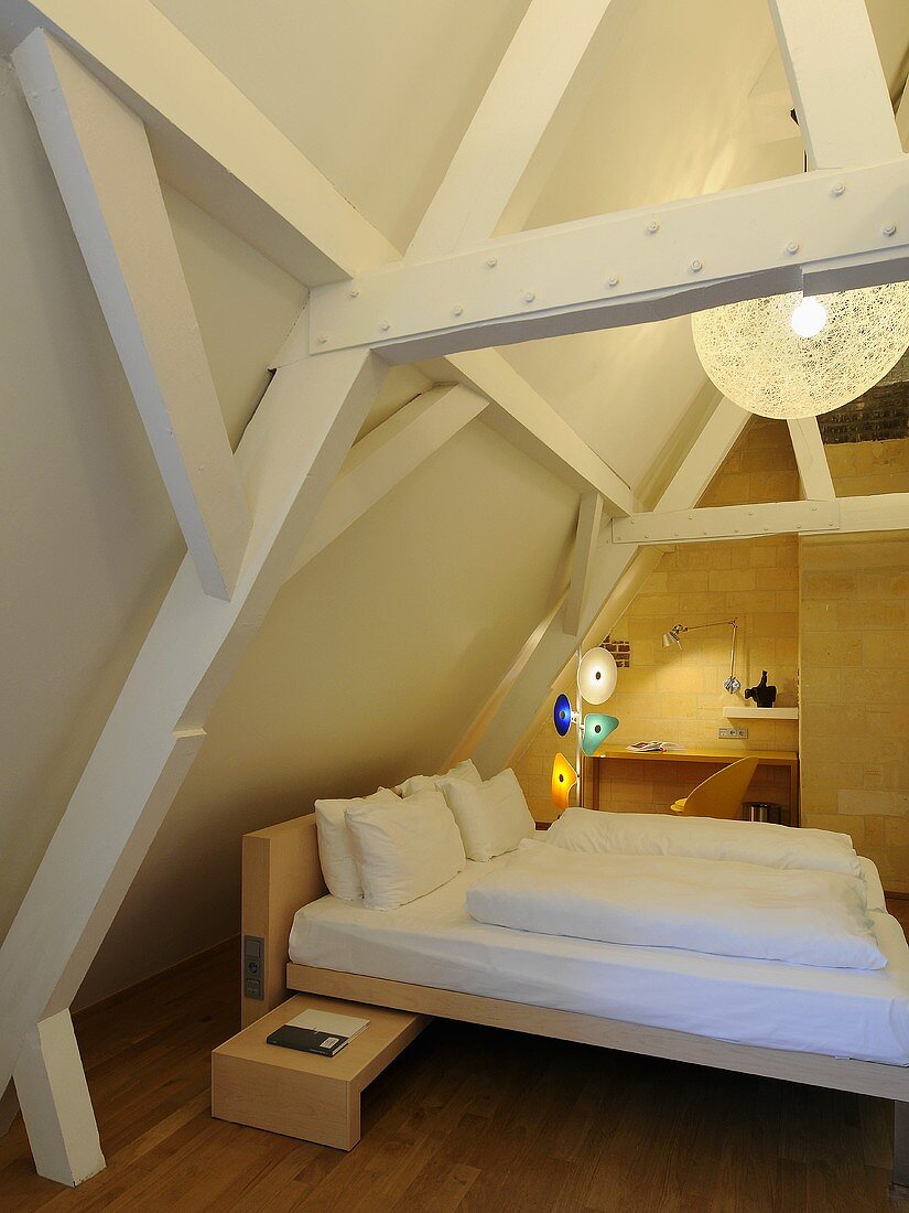 Designer Holzbett im Dachraum mit offener Holzkonstruktion