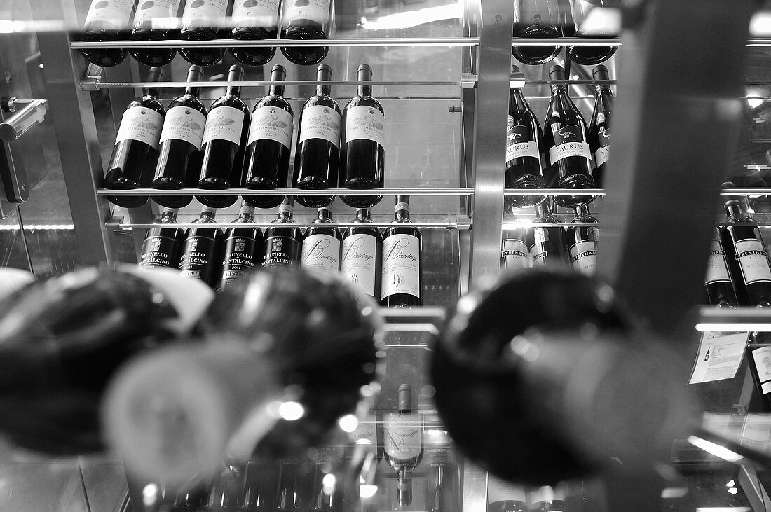 A black and white image of wine displayed on a glass shelf