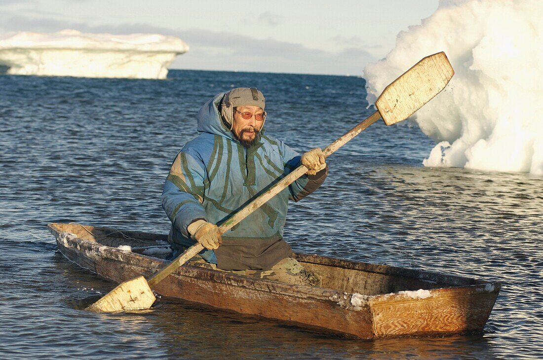 John Arnatsiaq, Inuit hunter paddling a kayak amongst pack ice  The kayak is used to retrieve seals that have been hunted from the water Igloolik or Iglulik, Nunavut, northern Canada October 2006
