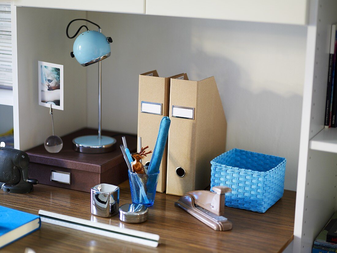 Table top with writing implements and blue floor lamp