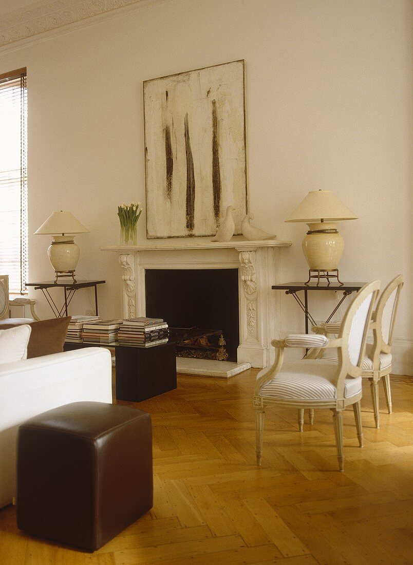 Upholstered chairs and sofa arranged around coffee table in front of fireplace