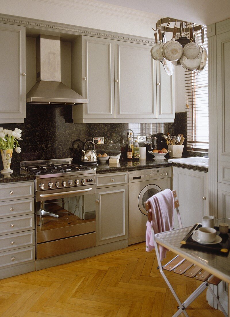 Kitchen with grey cupboards and stainless steel oven and extractor fan