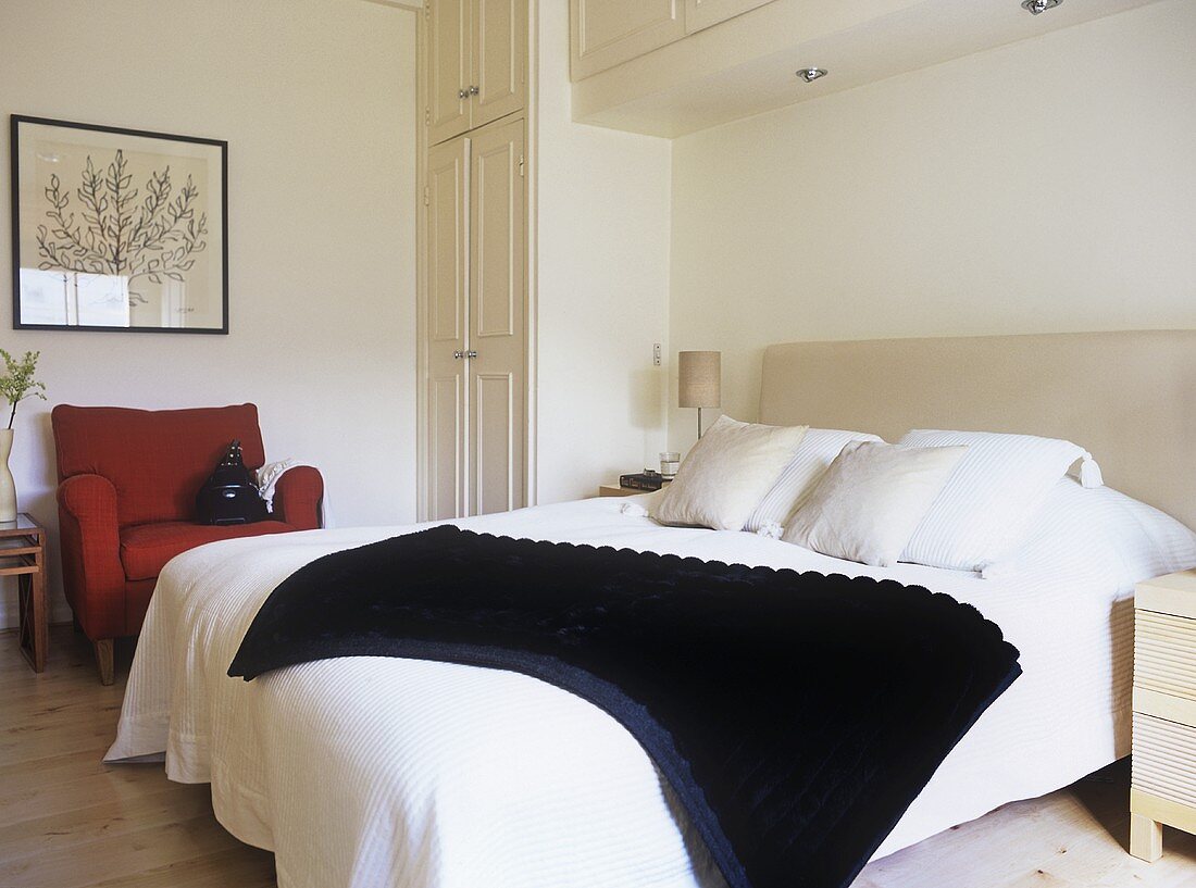 Modernes Schlafzimmer in neutralen Farben - Doppelbett mit gepolstertem Kopfteil und rotem Polstersessel