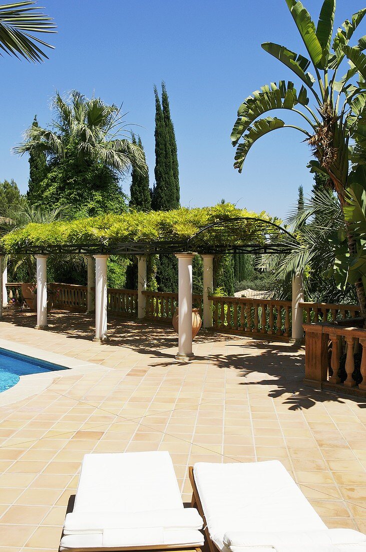 Sun loungers on patio next to swimming pool