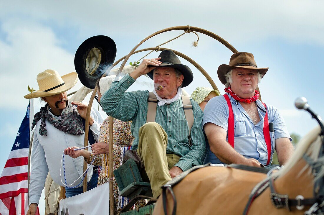 American settlers in a wagon at a 4th of July parade