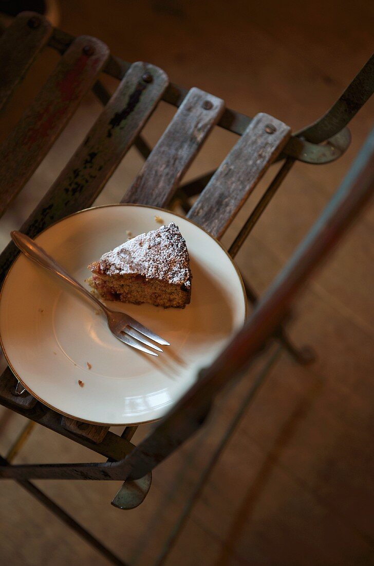 A slice of cake on a plate on a wooden chair