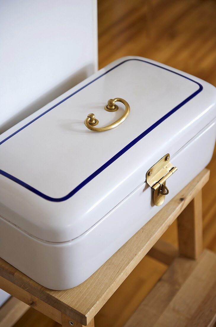 White tin box on wooden stool