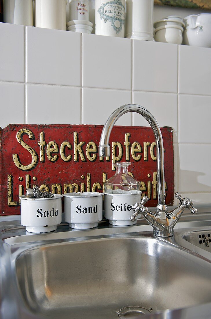 Küchenarmatur und Edelstahl-Spüle mit Vintage Metallgefässen