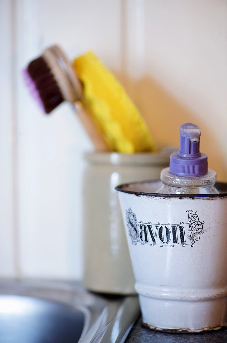 A soap dispenser in an old-fashioned metal container