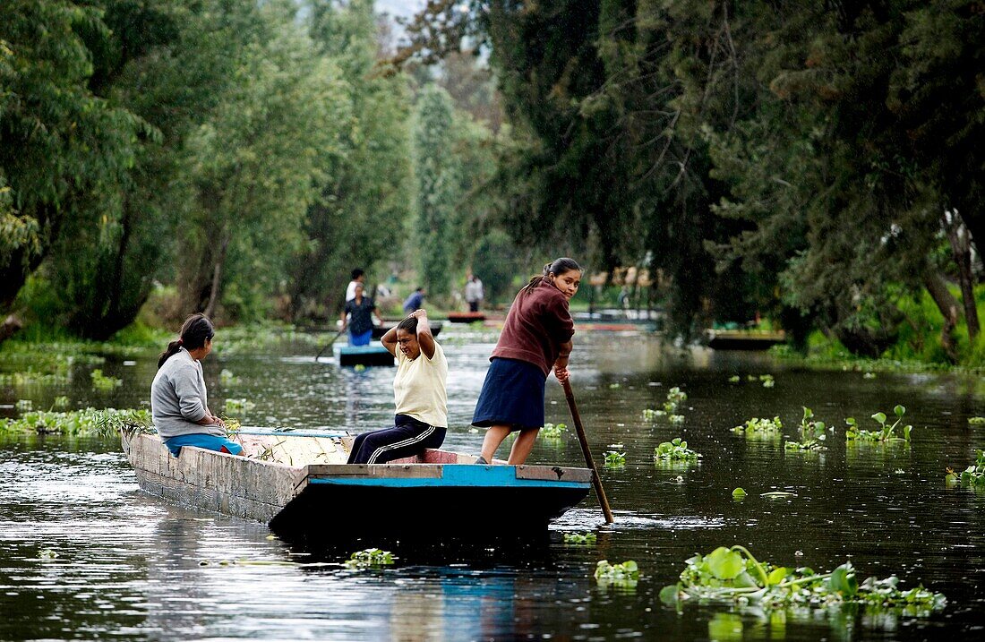 Residents ride in a boat through the water canals of Xochimilco on the south side of Mexico City. The water canals and gardens in Xochimilco was once part of the Americas breadbaskets and the agricultural hub of Tenochtitlán Aztec empire The water canals 