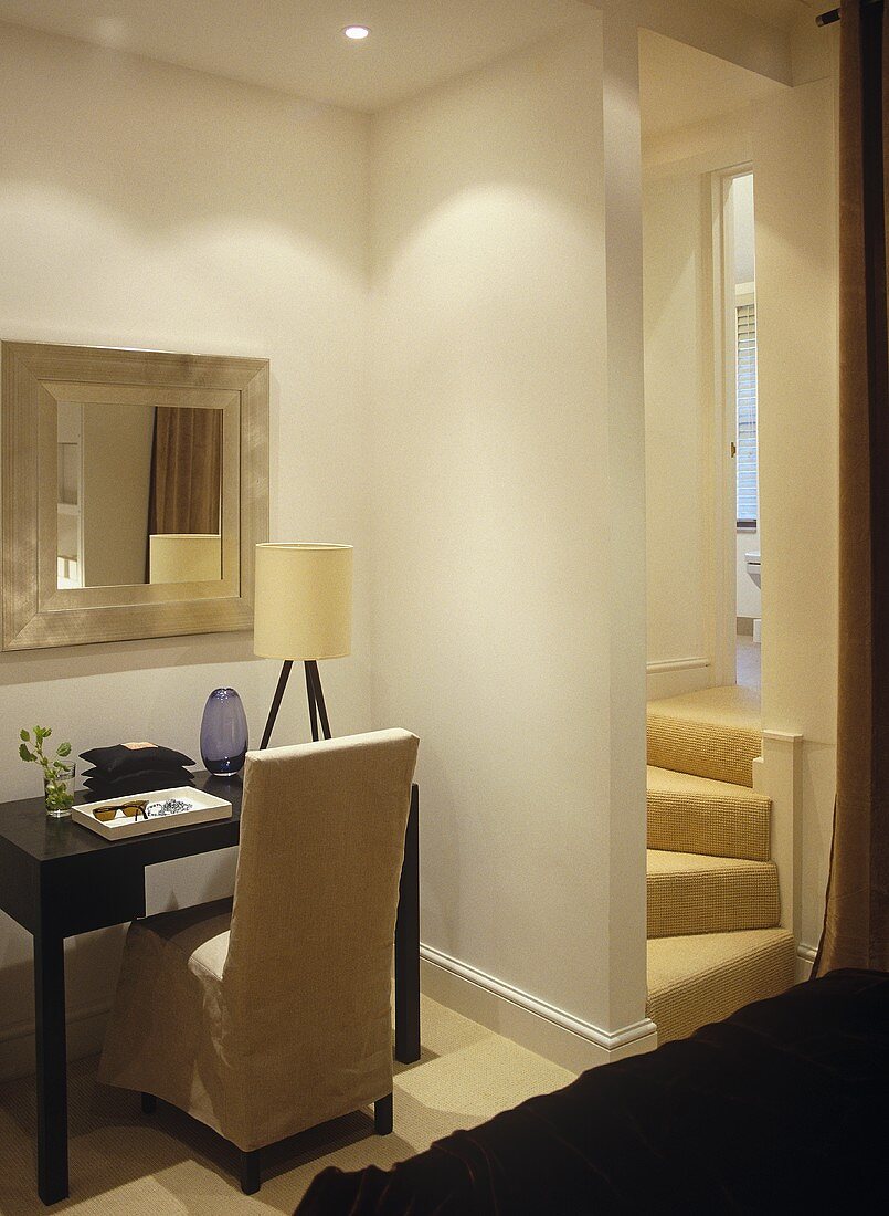 Linen covered chair at dressing table with mirror above